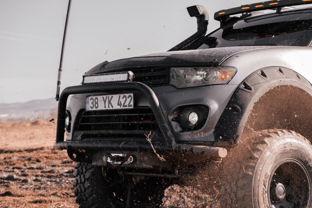 a black and white truck driving on a dirt road