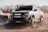 A rugged Ford Raptor equipped with Mammoth Truck wide body kit driving through rocky terrain.
