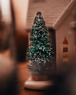 A cozy corner featuring small wood carvings and an artificial tree glowing with soft lights.