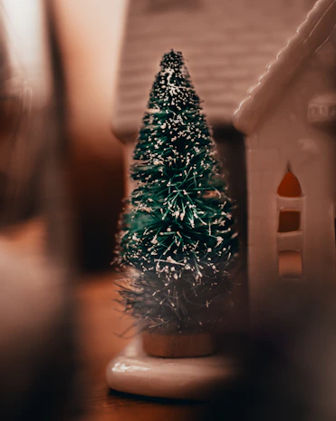 A cozy corner featuring small wood carvings and an artificial tree glowing with soft lights.