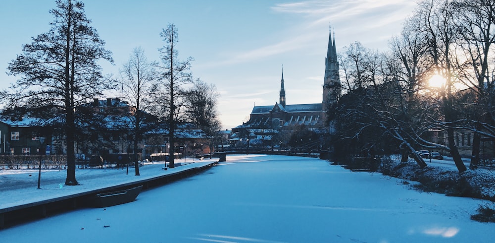 a snowy street with a church in the background