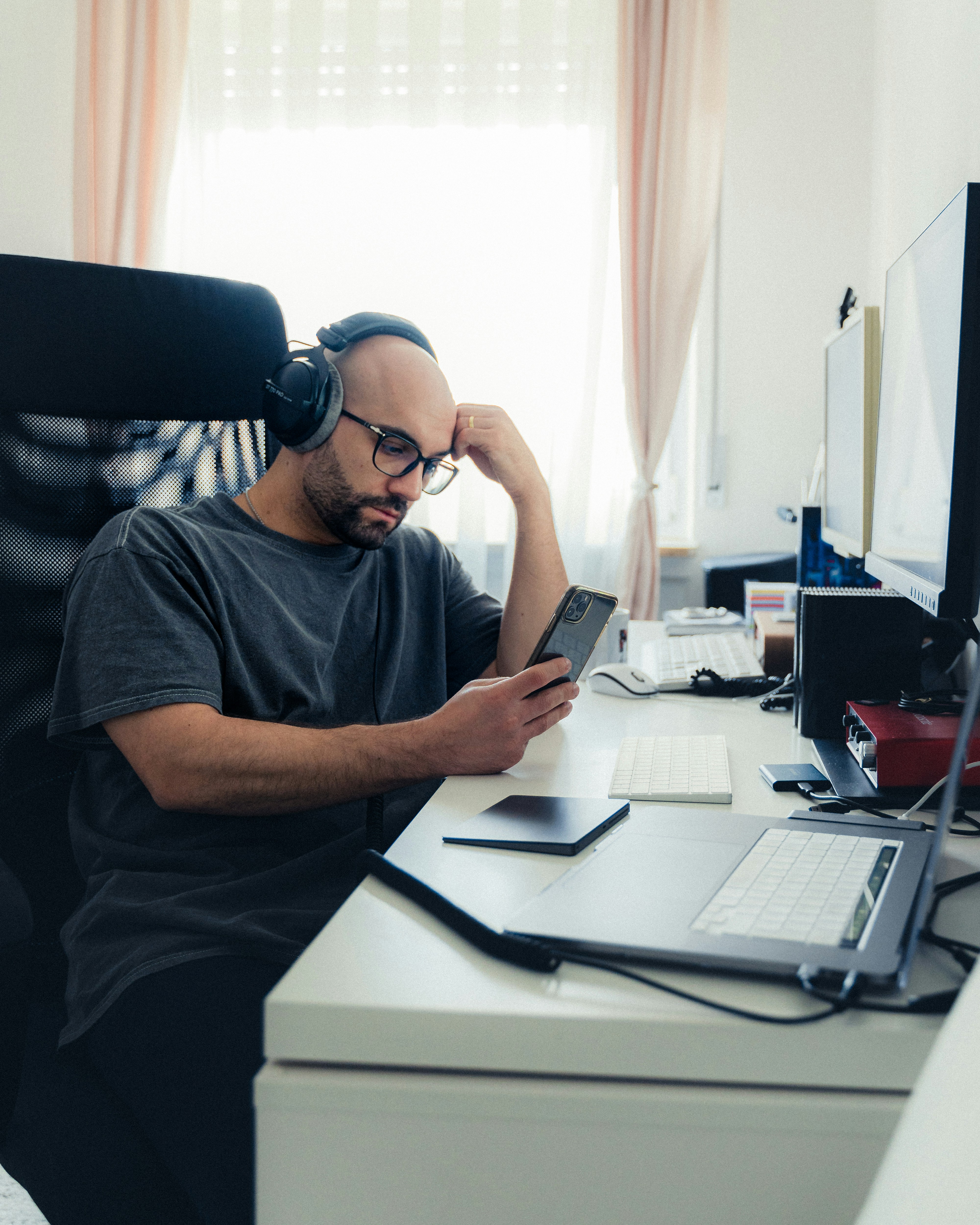 a man sitting at a desk with headphones on