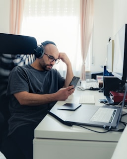 a man sitting at a desk with headphones on