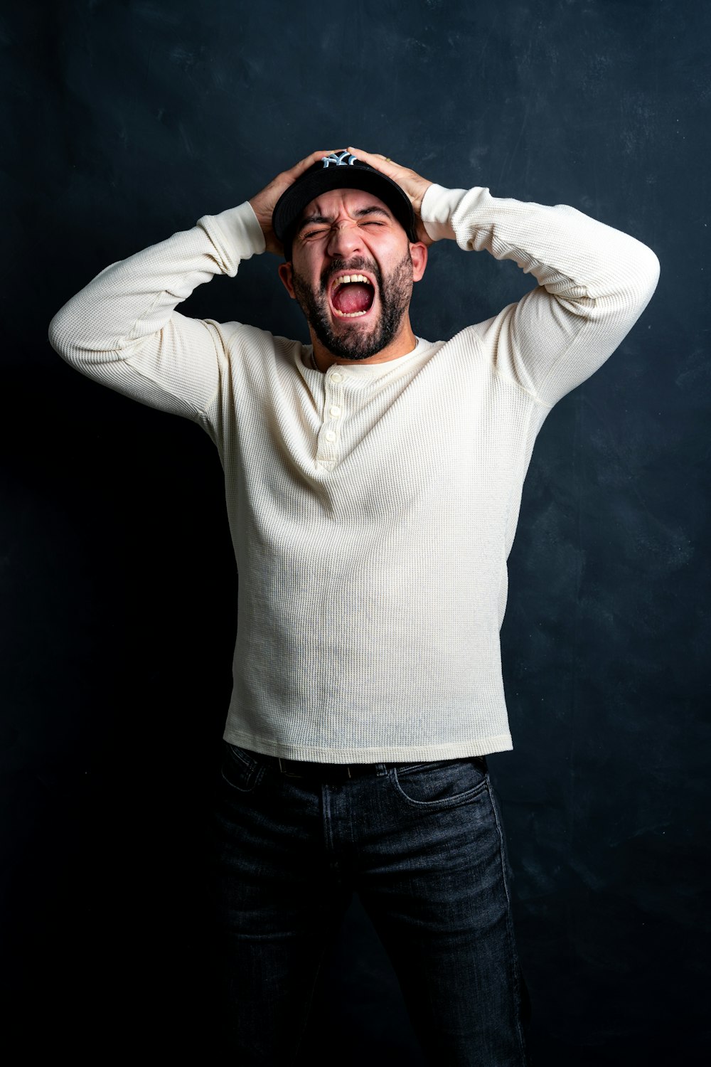 a man in a white shirt is holding his hands on his head