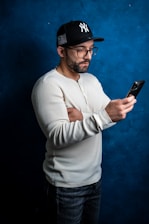 a man in a baseball cap looking at his cell phone