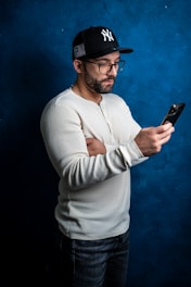 a man in a baseball cap looking at his cell phone