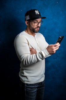 a man in a baseball cap looking at his cell phone