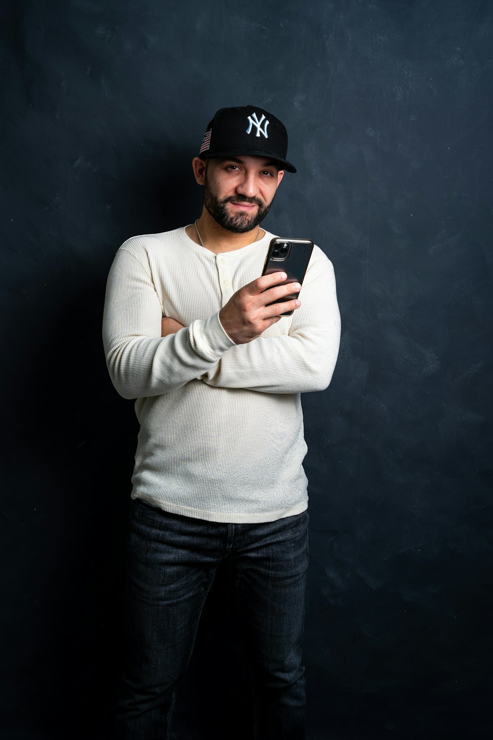 a man in a baseball cap holding a cell phone