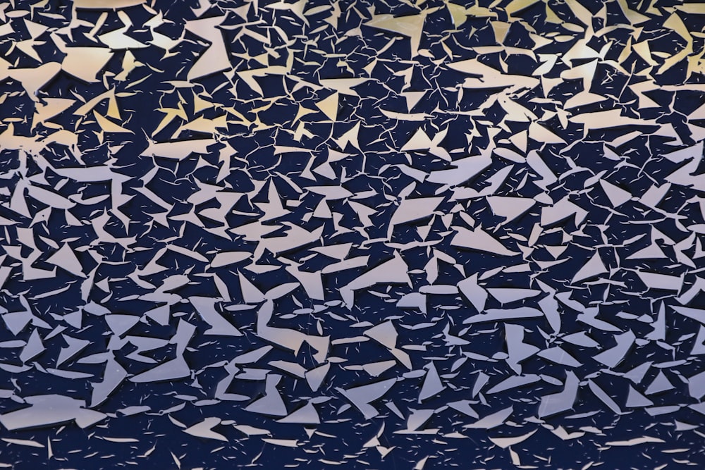 a large group of birds flying through a blue sky