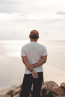 A serene outdoor scene with a person dressed in miga shorts and cap, reflecting resilience and calm.