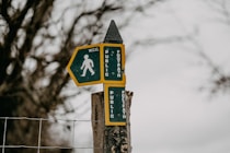 a street sign on a wooden post next to a fence