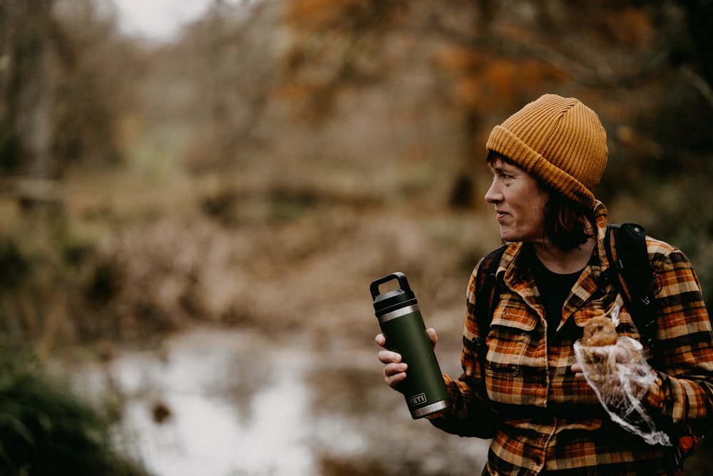 a woman in a plaid jacket holding a water bottle