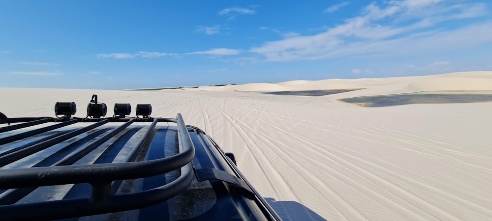 a truck driving down a sandy road in the desert