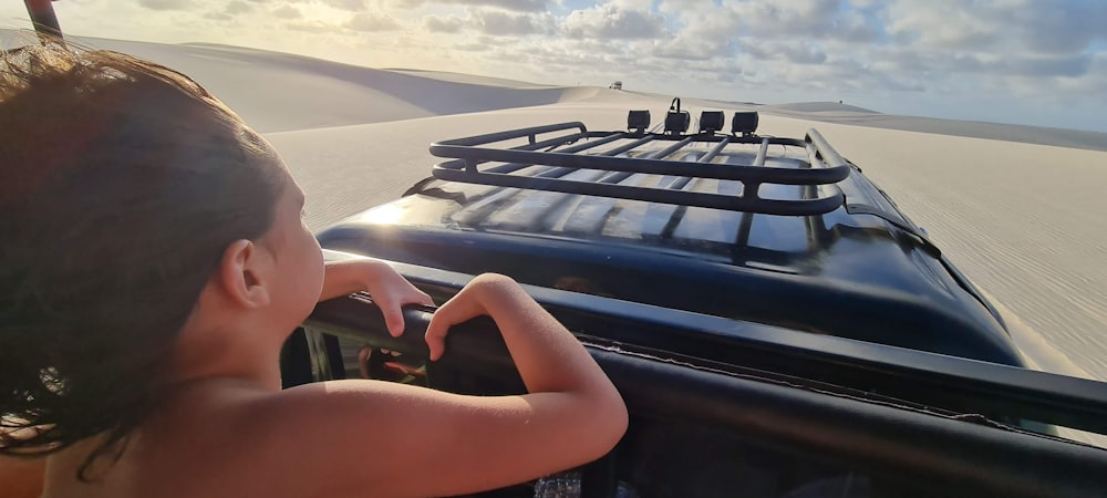 a woman driving a car in the desert