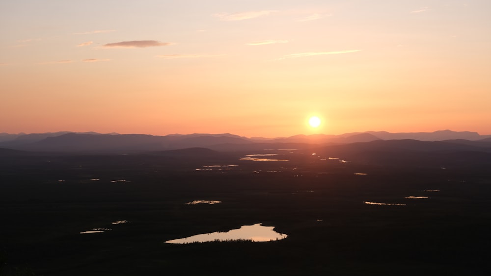 the sun is setting over a mountain range