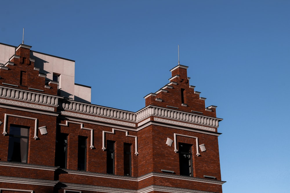 a tall brick building with two clocks on each of it's sides