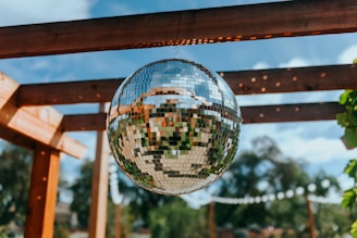 a disco ball hanging from a wooden pergolan