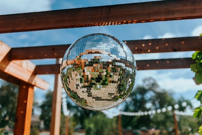 a disco ball hanging from a wooden pergolan