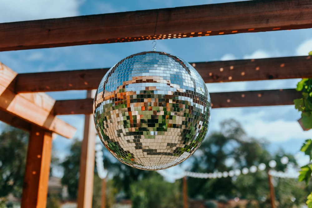 a disco ball hanging from a wooden pergolan