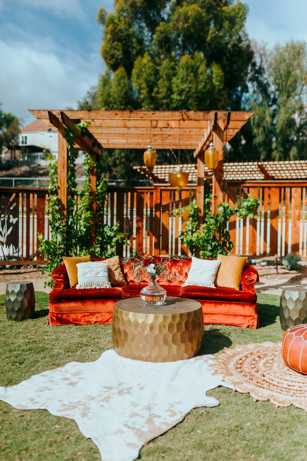 a red couch sitting on top of a lush green field