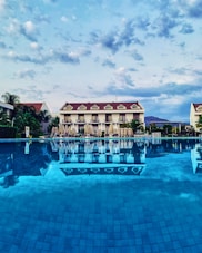 a large swimming pool with a hotel in the background