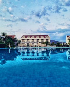 a large swimming pool with a hotel in the background
