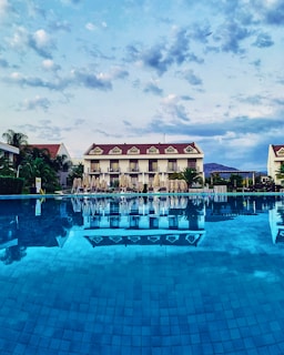 a large swimming pool with a hotel in the background