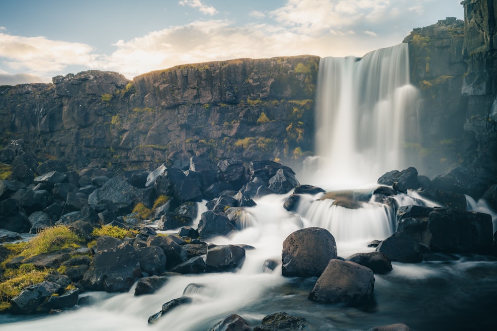 a waterfall with a mountain in the background