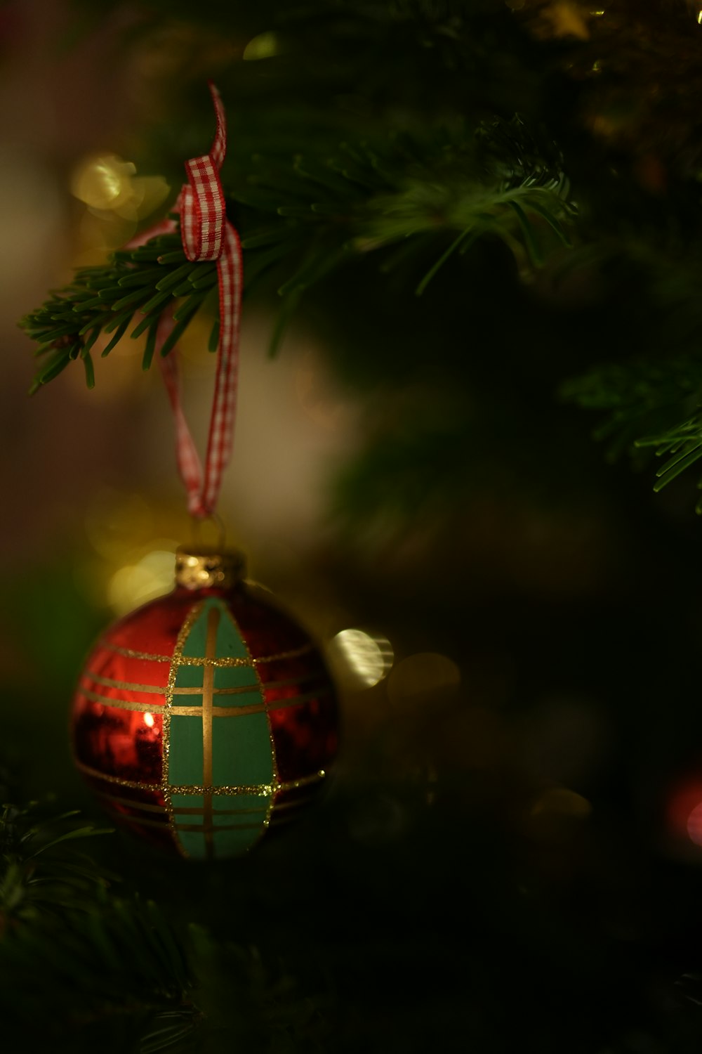 um ornamento vermelho e verde pendurado em uma árvore de Natal