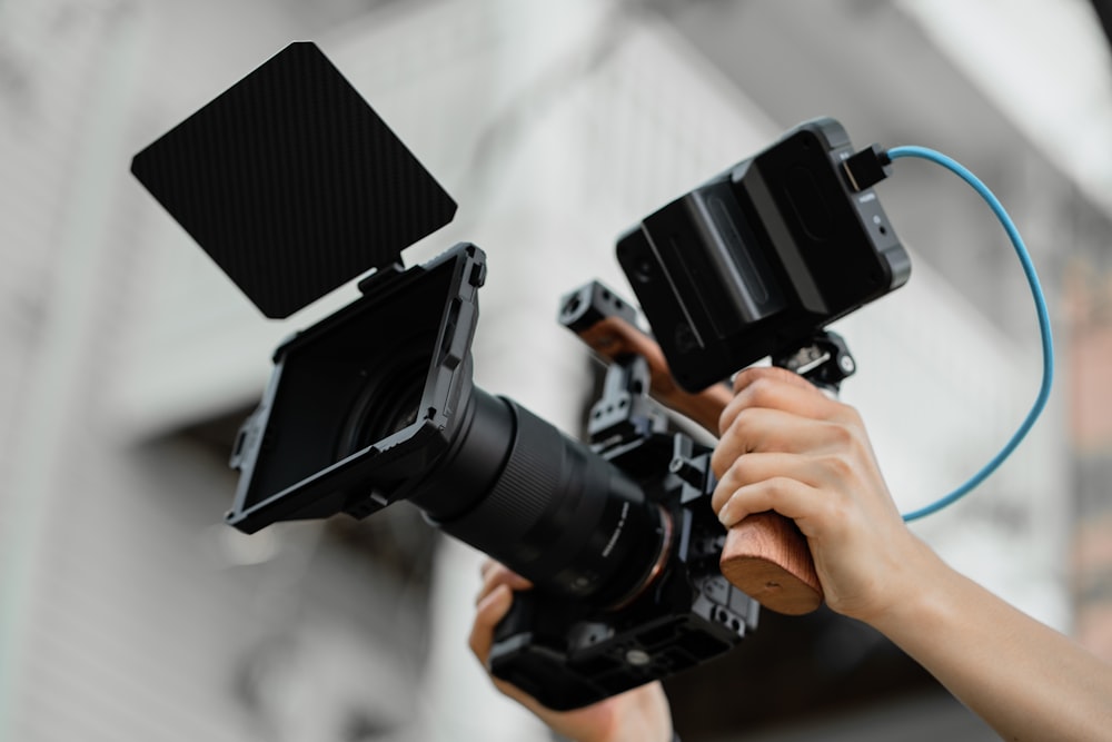 a person holding a video camera in their hand