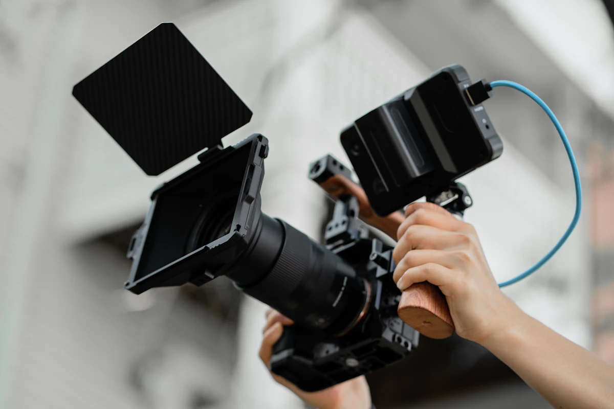 Seorang konten kreator memegang kamera video untuk merekam konten dengan sentuhan personal yang autentik dan tidak tergantikan AI