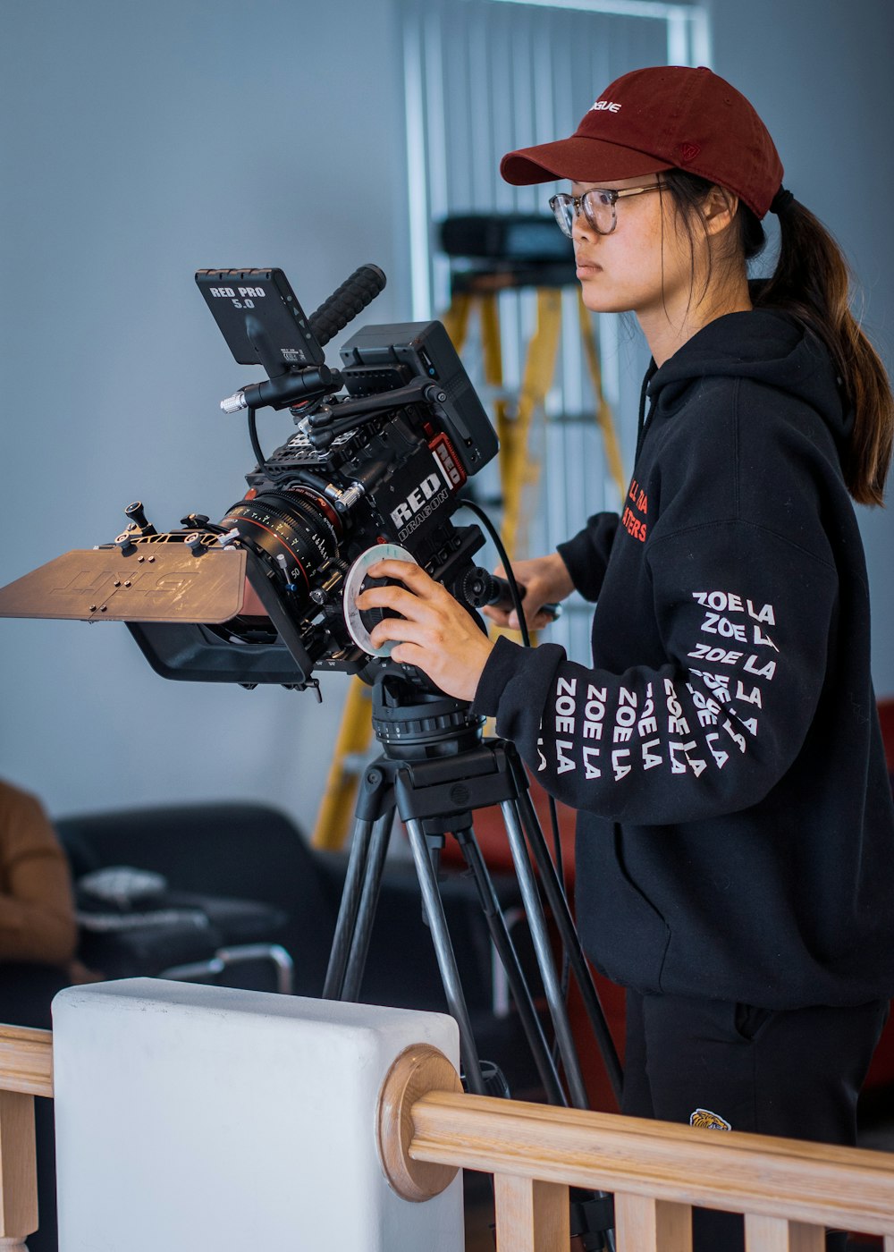 a woman standing in front of a camera on a tripod