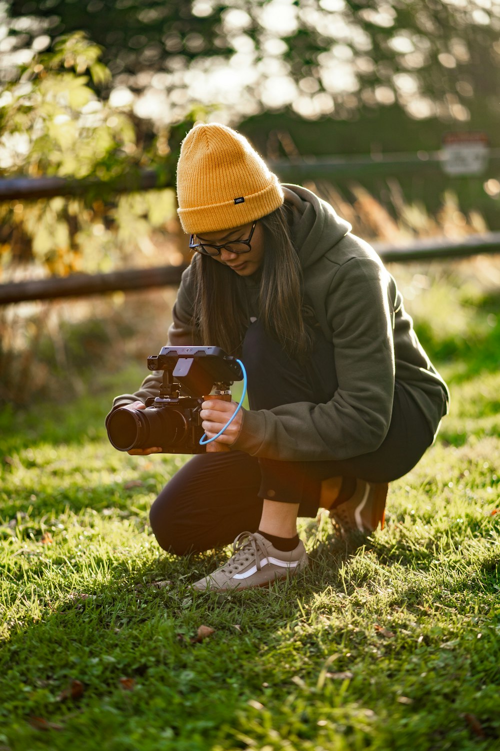 a woman kneeling down while holding a camera