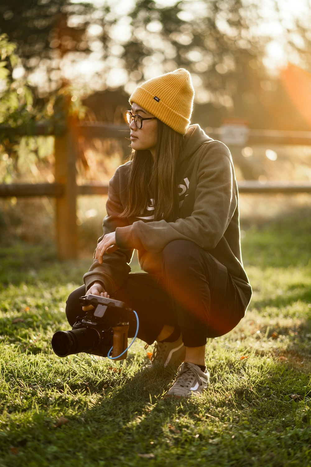 a woman sitting in the grass with a camera