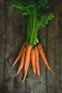a bunch of carrots sitting on top of a wooden table