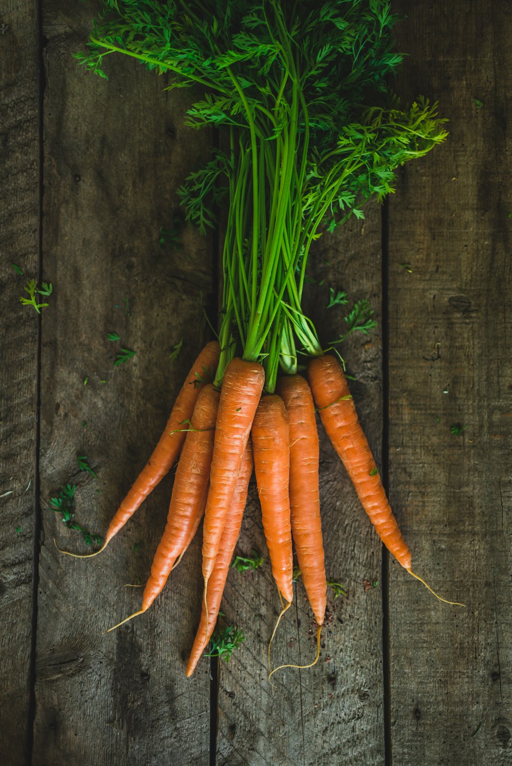 a bunch of carrots sitting on top of a wooden table