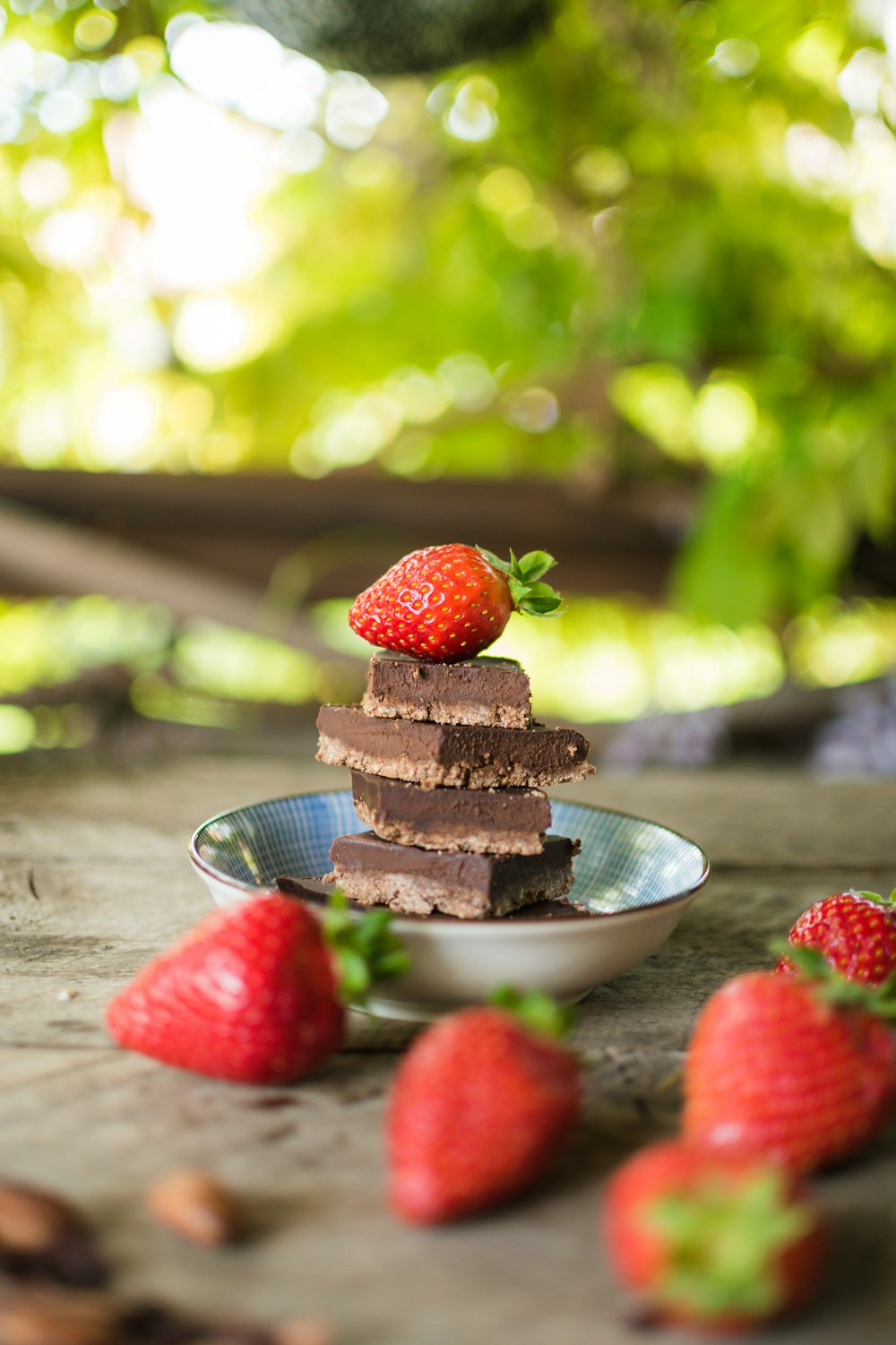 a stack of brownies with strawberries on a plate