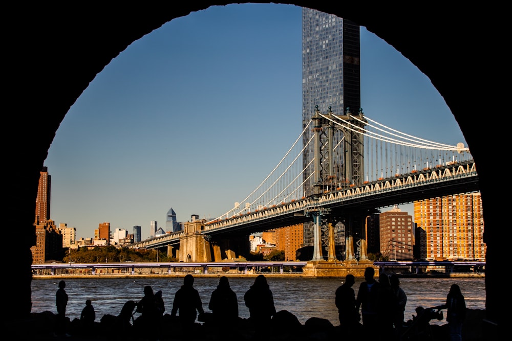 a group of people standing in front of a bridge