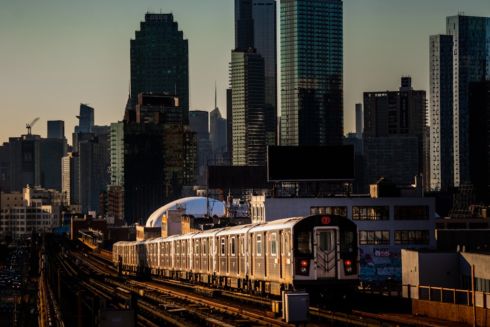 Un train traversant une ville à côté de grands immeubles