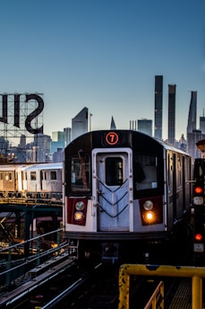 a train on a train track with a city in the background