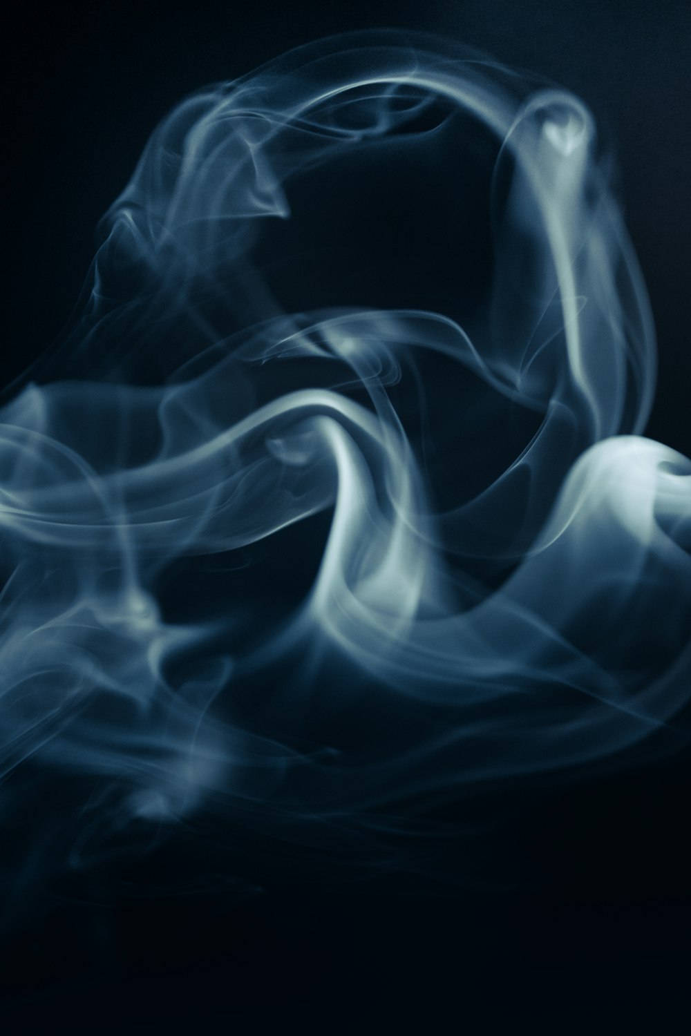 ein blauer Rauch wirbelt auf schwarzem Hintergrund