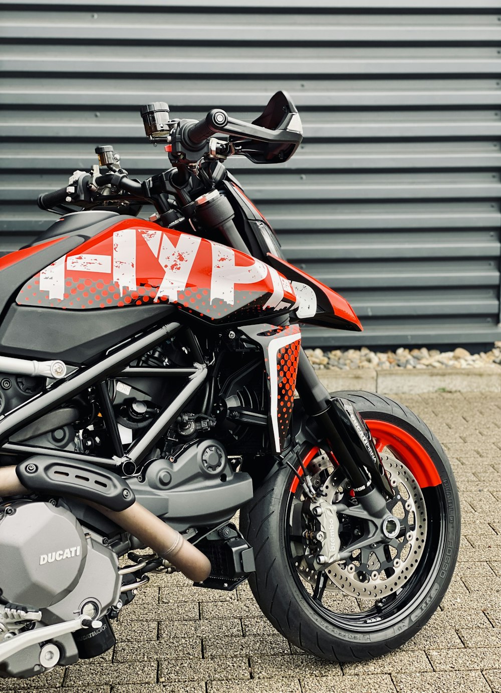 a red and black motorcycle parked in front of a building