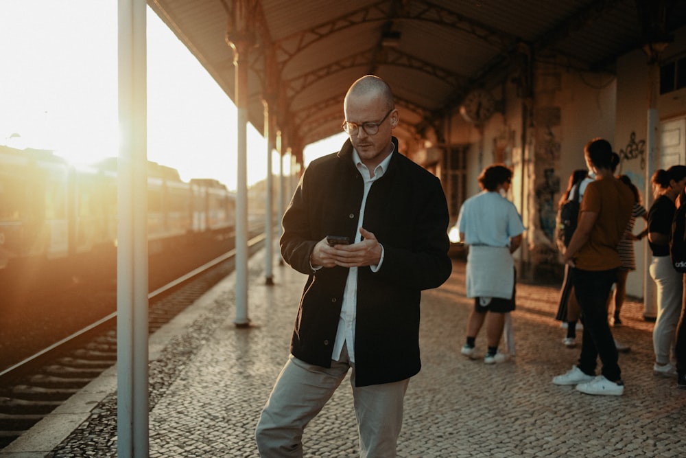 a man standing on a train platform next to a train