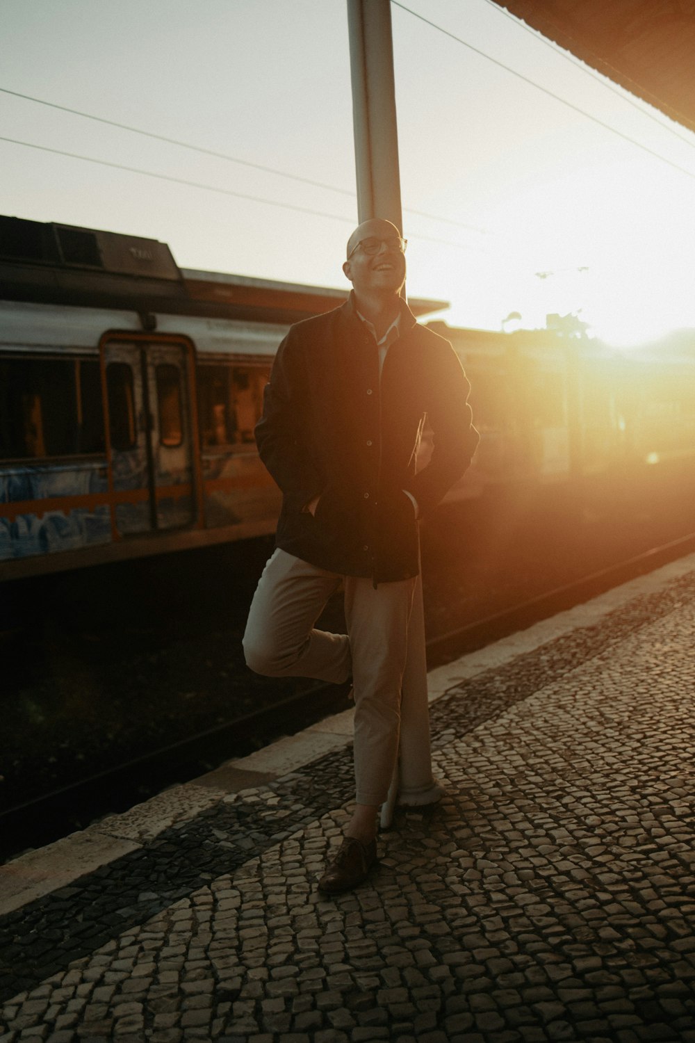 a man standing on a train platform next to a train