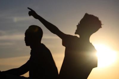 An evocative image of two sisters silhouetted against a sunset, symbolizing 'My Outlaw Sister.'