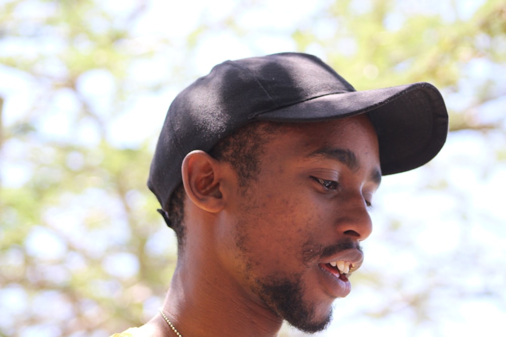 a man wearing a black hat while talking on a cell phone