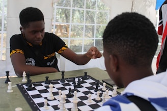 a young man playing chess with another young man