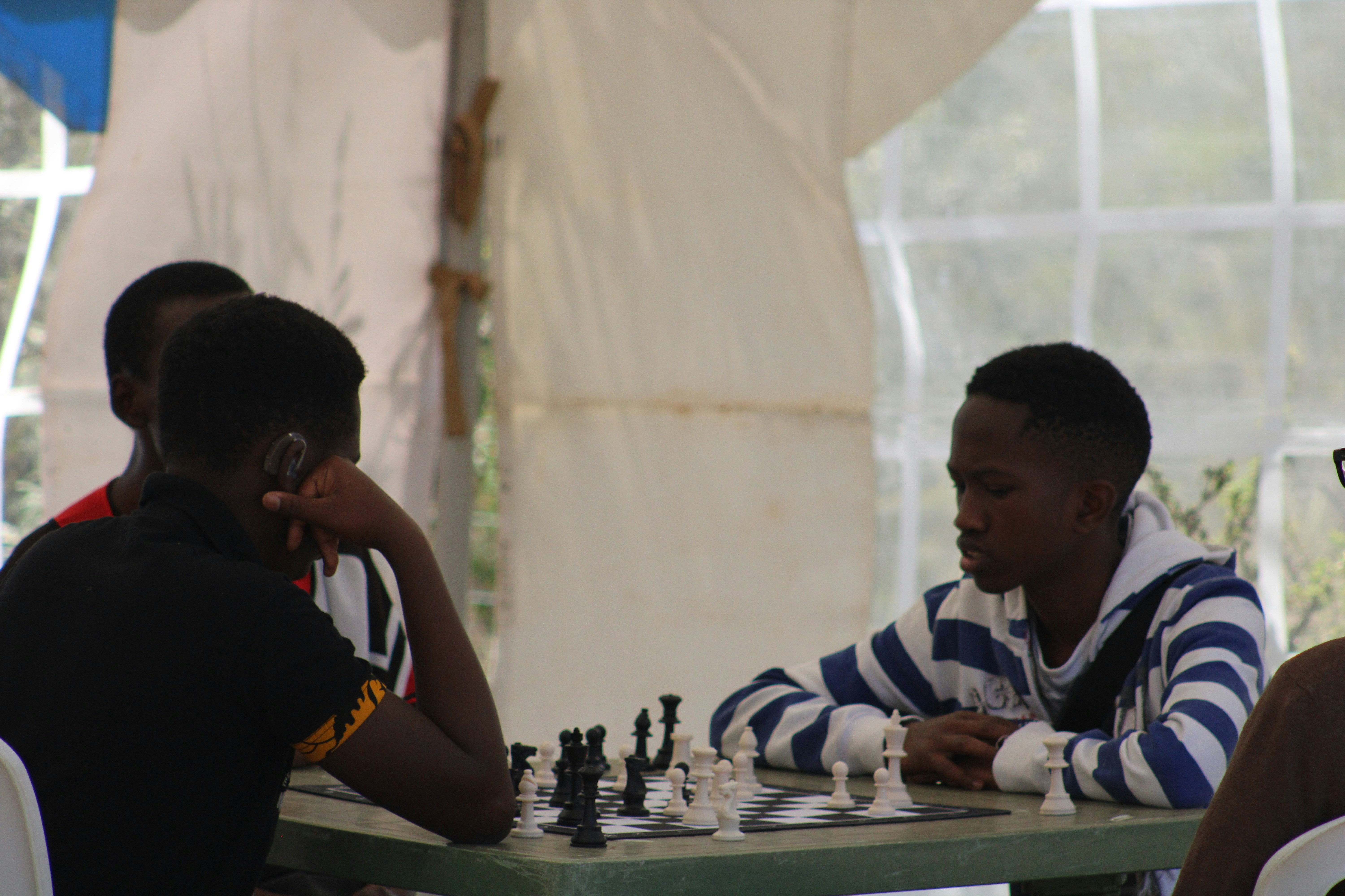 two men sitting at a table playing chess
