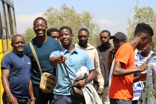 a group of men standing in front of a bus