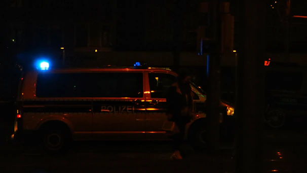 Mobile locksmith van parked outside a home at dusk with flashing lights.